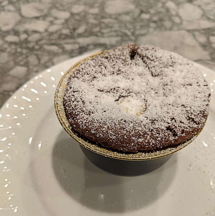 The soufflé filled with creme anglaise and topped with powdered sugar.